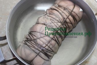 Перетянутый марлей и нитками свиной рулет поместить в кастрюлю и залить холодной водой Перетянутый марлей и нитками свиной рулет поместить в кастрюлю и залить холодной водой